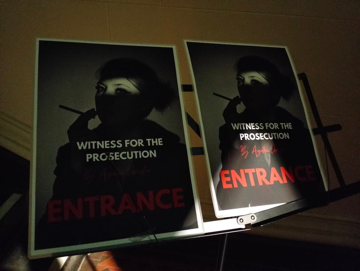 A music stand holding two posters for the theatre production.