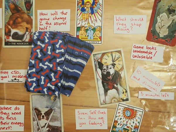 Various Tarot cards laid out on a table with hand-written questions on scraps of paper.