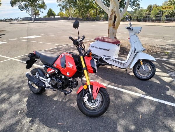 A red Honda Grom and a white Lambretta V-Special 200