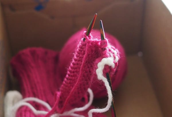 Knitting work in progress inside a shoebox.