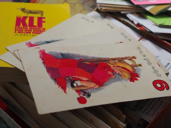 Old birthday cards and a book, stacked on top of a shoebox full of letters.