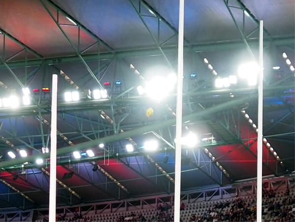 A Sherrin football flying through the posts at Marvel Stadium.